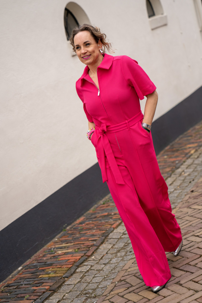 Sytha jr loopt in een jumpsuit knalrose met korte mouw van pom, te koop in Winsum